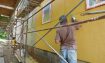 Stucco contractor applying integral ochre-pigmented finish coat